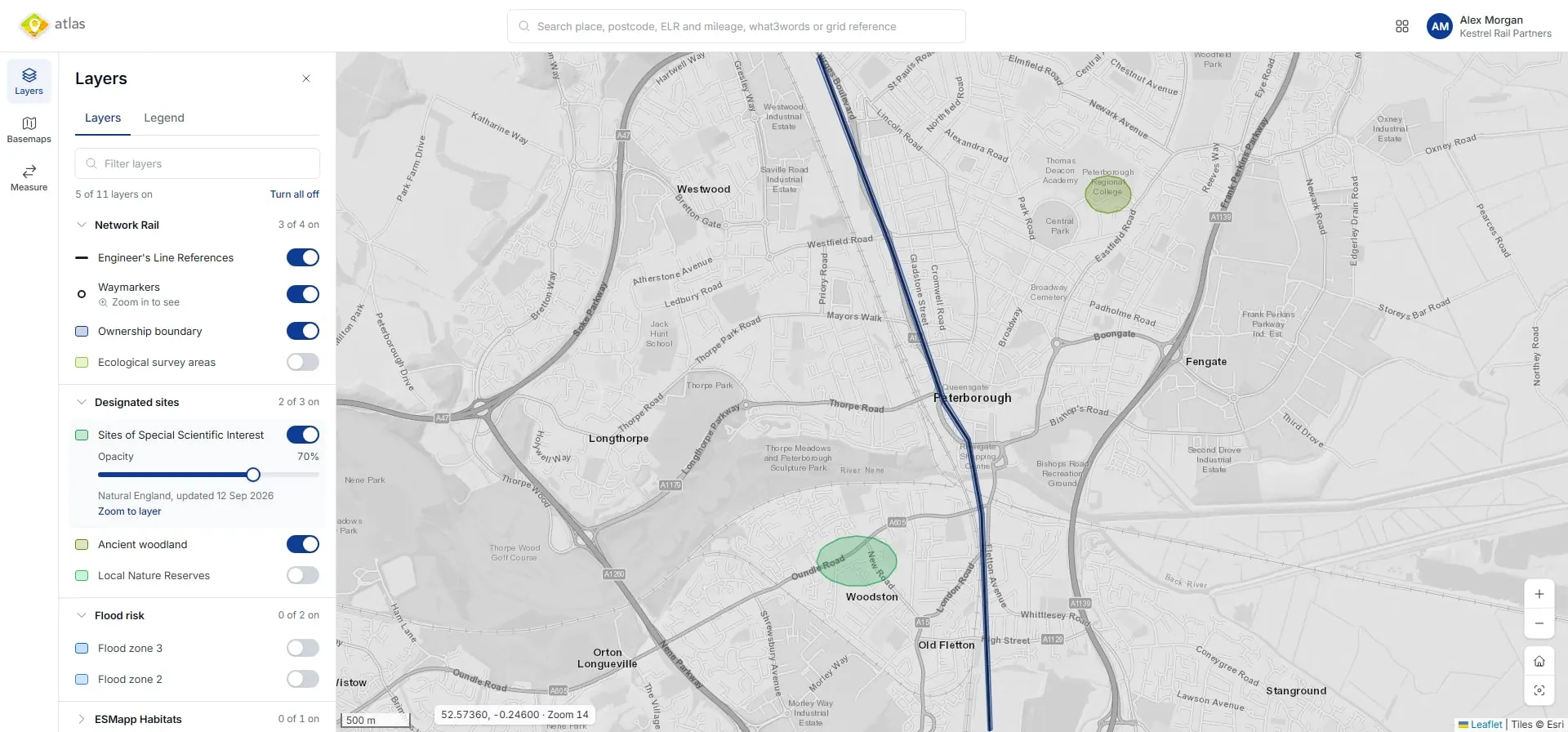 The Atlas map viewer over Peterborough: a Layers panel with Network Rail, designated sites and flood risk groups, five of eleven layers switched on, and Sites of Special Scientific Interest set to 70% opacity. The map shows a rail line and Engineer’s Line References, with two designated sites shaded green.